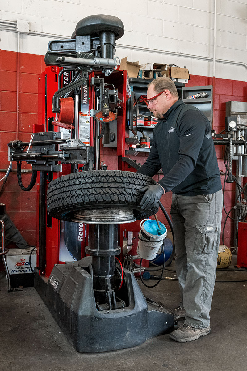 tc-tcr-realshop-bernhardautoworks05.jpg technician mounting tire on revolution