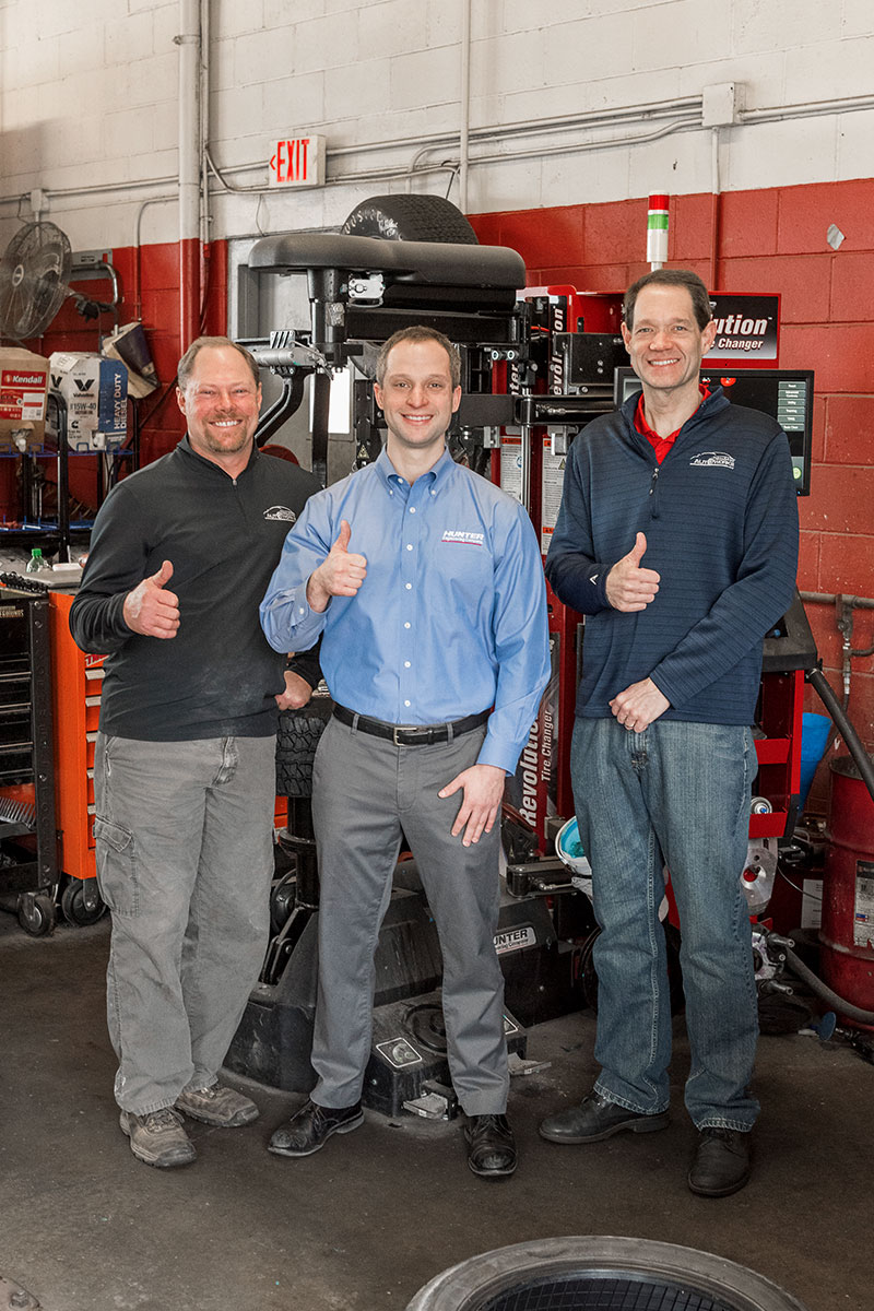 tc-tcr-realshop-bernhardautoworks08.jpg three males giving thumbs up in front of hunter revolution tire changer