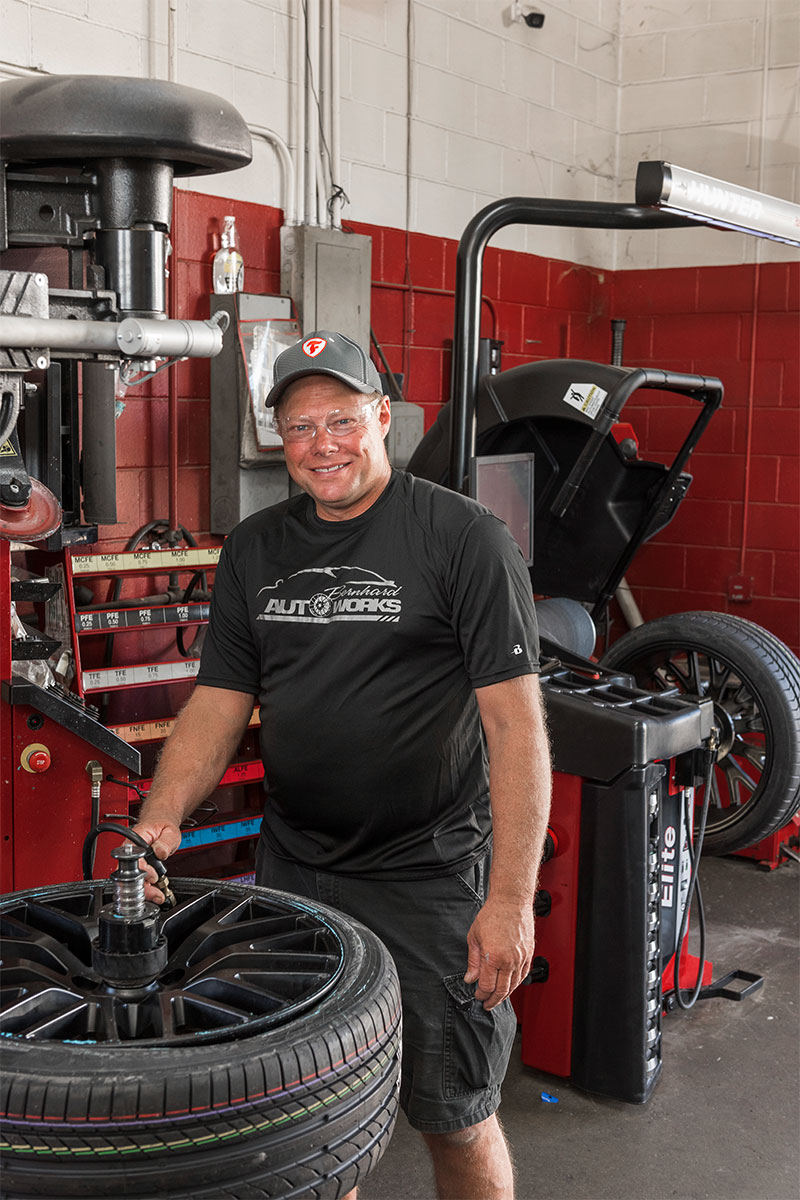 tc-tcr-realshop-bernhardautoworks11.jpg technician smiling while using blast inflation on revolution tire changer