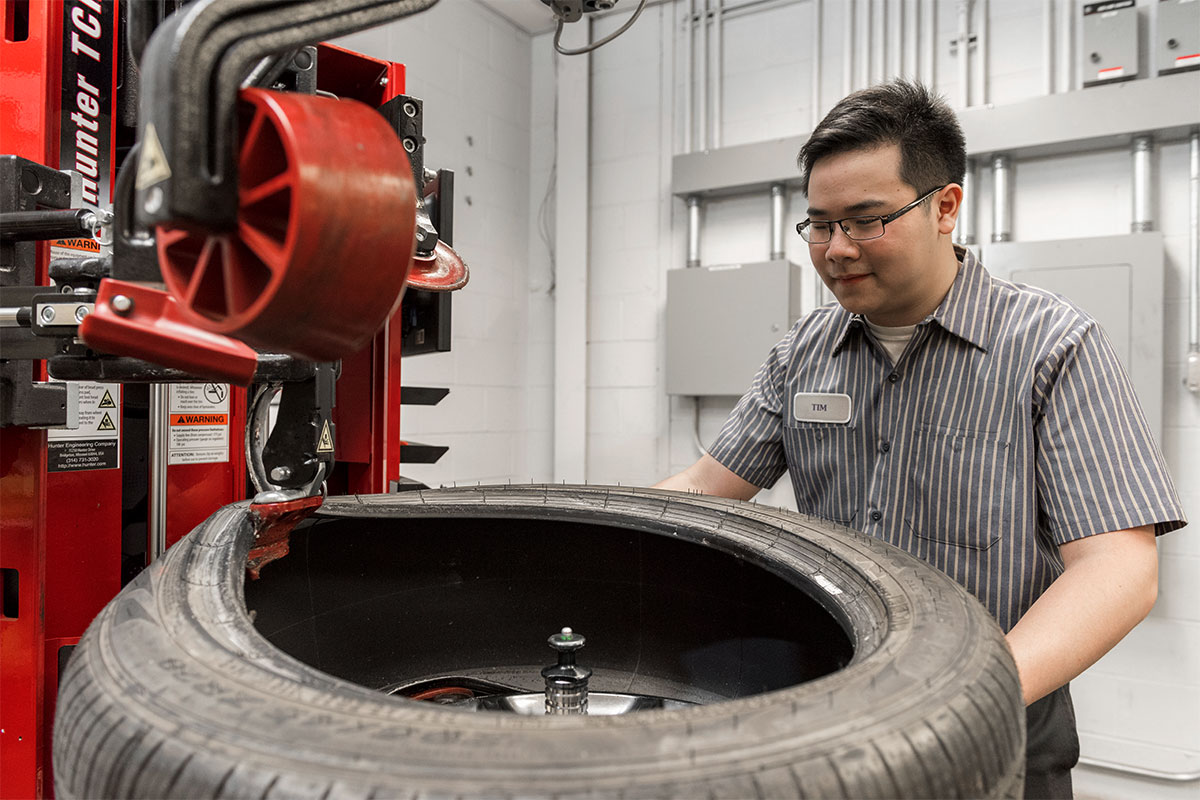 tc-tcr-realshop-martycancilla2.jpg closeup of male demounting tire on autonomous tire changer